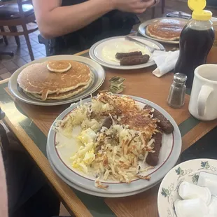 a breakfast of pancakes, eggs, hash browns, and coffee
