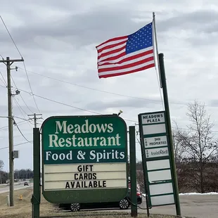 a sign for meadows restaurant and spirits