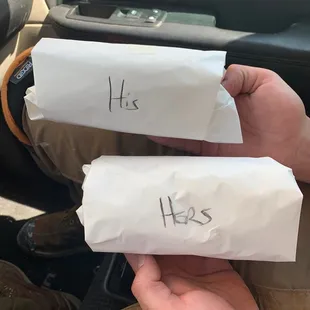 a person holding two hot dogs