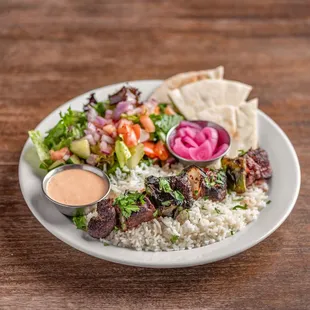 Beef Tenderloin Plate with basmati rice, house salad, pita bread slices, your choice of in-house made sauce and pickled red onions.