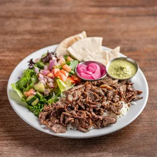 Döner Plate with basmati rice, house salad, pita bread slices, your choice of in-house made sauce, and pickled red onions.