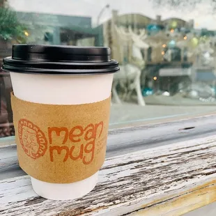 a cup of coffee on a window sill