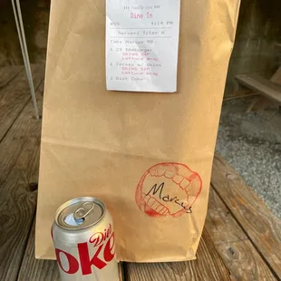 a paper bag and a can of coke