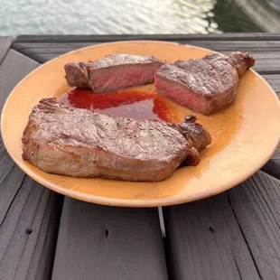 two steaks on a yellow plate