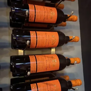 a wall of wine bottles with orange labels