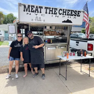 two people standing in front of a food truck