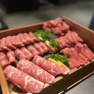 a tray of raw meat and broccoli
