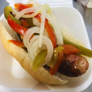 a hot dog with onions and peppers