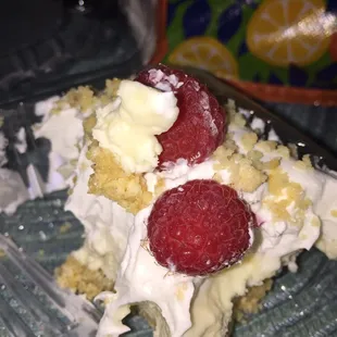 a piece of cake with whipped cream and raspberries