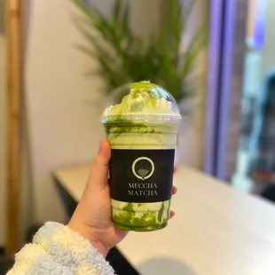 a person holding a cup of matcha
