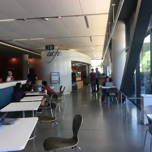 people sitting at tables in a cafeteria