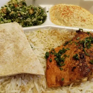 Salmon and rice with hummus, tabouleh, and pita.