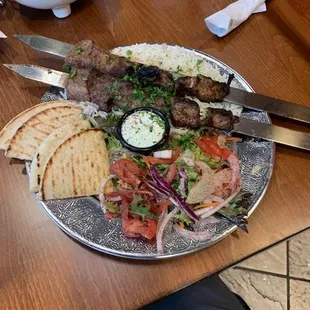 Lamb kabob with salad and pitas,