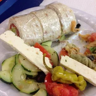 Combo meal, small roll up sandwich with two sides, greek salad and pasta salad.