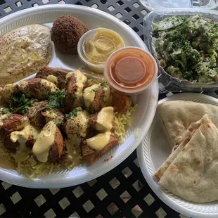 Chicken kabob with rice, hummus, pita, falafel and tabbouleh.