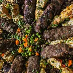 Beefy &amp; shishtawouq kebabs on cinnamon rice garnished w/steamed vegetables and seasoned ground beef