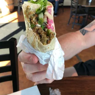 a hand holding a burrito