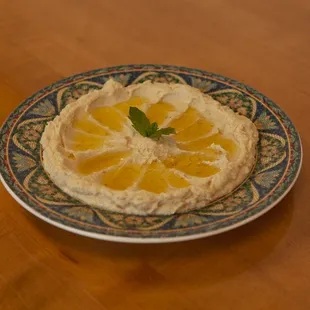 a plate of hummus and oranges