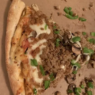 a slice of pizza with meat and vegetables