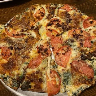 Delicious white pizza topped with bacon and tomato. Cauliflower crust was just the right amount of crispy