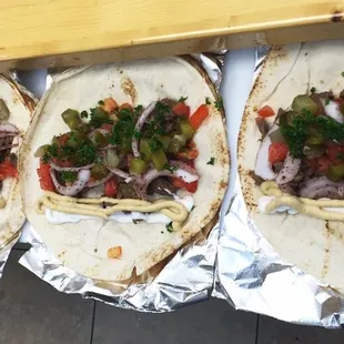 a row of tortillas with various toppings