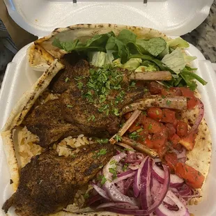 Lamb chop, bowl, tomatoes, lettuce, onions, bread, and lamb chops along with rice pilaf, very tasty!!