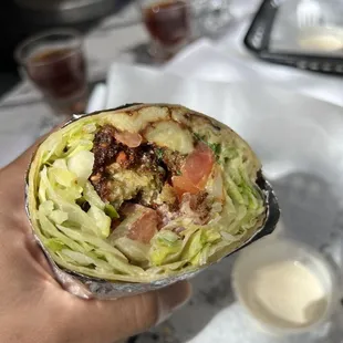a hand holding a burrito