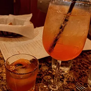 Left side: galliano old fashioned Right side: aperol spritz