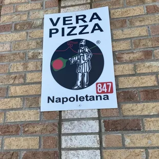 a sign on a brick wall