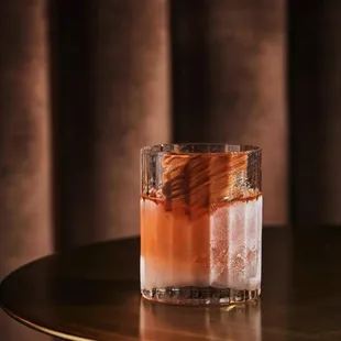 a glass filled with a drink on a table