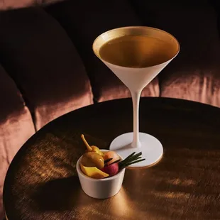 a cocktail in a martini glass on a table