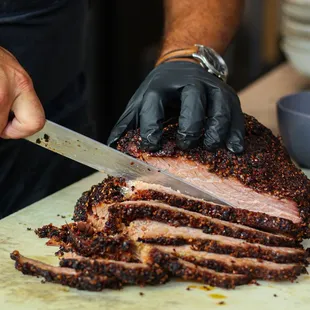 a person cutting a meat on a cutting board