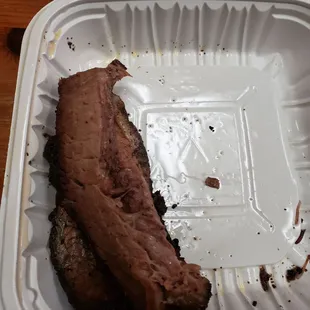 a piece of meat in a styrofoam container