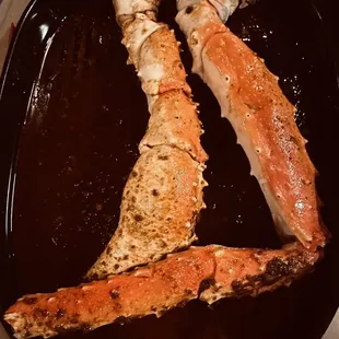 two cooked crabs on a black plate