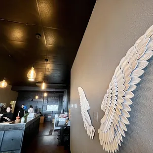 a large white angel wing on the wall of a restaurant