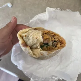 a hand holding a burrito