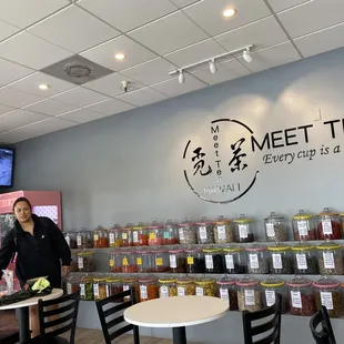 two people standing in front of a wall of tea