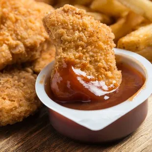 a fried chicken nugg with ketchup and french fries