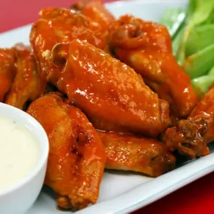 a plate of buffalo wings and celery