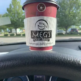 a cup of coffee on a steering wheel