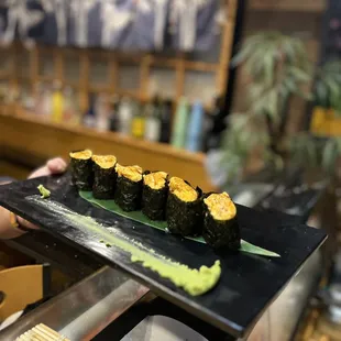 a woman holding a plate of sushi