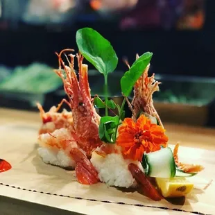 a sushi dish with shrimp and vegetables