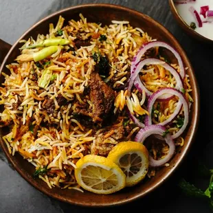 Mutton biryani is a dish of basmati rice cooked with spices and layered with mutton (goat meat) that has been marinated in yogurt and cooked