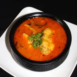 Mehfil Indian Cuisine, Fish pulusu is a dish of fish cooked in a tangy tamarind gravy with spices, onions, tomatoes and curry leaves.