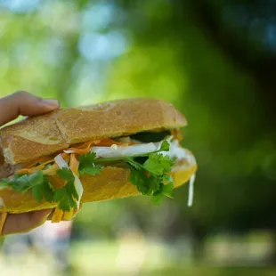 a person holding a sandwich in their hand