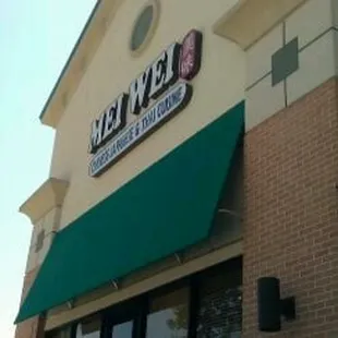 the front of a restaurant with a green awning