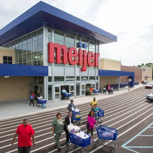a group of people with shopping carts in front of a store