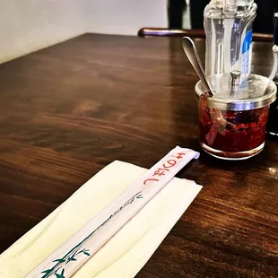 a wooden table with a blender and two chopsticks