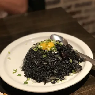 a plate of black rice and a spoon