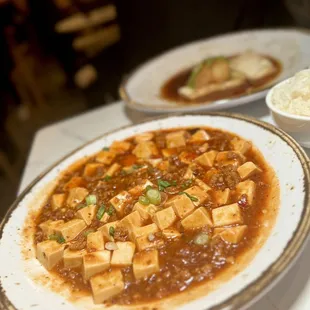 Mapo Tofu made with soft tofu sauteed with minced Berkshire pork, topped with chili oil and scallions.